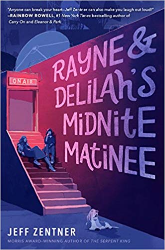 Sitting on stairs leading to a recording studio, sit two girls who are against a wall that reads the bookâ€™s title: Rayne & Delilahâ€™s Midnite Matinee. A dog is at the bottom of the stairs looking towards the title. 