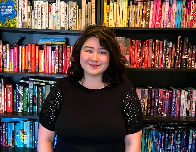 Author Erin Yun standing in front of a colorful bookshelf.